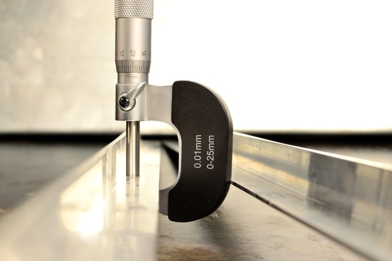 A steel measuring device measuring the width of a sheet of steel.